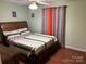 Cozy bedroom featuring a wooden bed frame, warm tones and natural light at 7316 Truelight Church Rd, Mint Hill, NC 28227