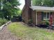 Brick house with chimney and gated back yard and side patio with umbrella and chairs at 7316 Truelight Church Rd, Mint Hill, NC 28227