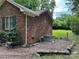 Brick house with chimney and gated back yard and side patio with umbrella and chairs at 7316 Truelight Church Rd, Mint Hill, NC 28227