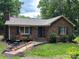 Charming brick home with mature landscaping and walkway leading to the front door at 7316 Truelight Church Rd, Mint Hill, NC 28227