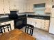 Functional kitchen with white cabinets, black appliances, and a cozy dining area, perfect for casual meals at 7316 Truelight Church Rd, Mint Hill, NC 28227