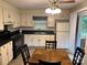 Traditional eat-in kitchen featuring white cabinets, black appliances, and a view to the backyard at 7316 Truelight Church Rd, Mint Hill, NC 28227