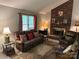 Comfortable living room with brick fireplace, ample seating, and a well-lit, inviting atmosphere at 7316 Truelight Church Rd, Mint Hill, NC 28227