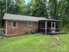 Back exterior view with a screened in back porch surrounded by a lush green lawn at 7316 Truelight Church Rd, Mint Hill, NC 28227