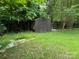 Utility shed in backyard with double doors and metal roof and surrounded by trees at 7316 Truelight Church Rd, Mint Hill, NC 28227