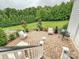 Stone patio in backyard with chairs, grill, landscaping and view of expansive lawn at 735 Davidson Run Ln, Davidson, NC 28036