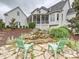 Landscaped backyard featuring a stone patio, waterfall, pond, and seating area at 735 Davidson Run Ln, Davidson, NC 28036