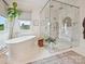 Modern bathroom featuring a standalone tub and luxurious glass enclosed shower with multiple shower heads at 735 Davidson Run Ln, Davidson, NC 28036