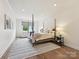 Bright bedroom featuring a four-poster bed, hardwood floors, and a comfortable sitting area at 735 Davidson Run Ln, Davidson, NC 28036