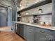 A built-in coffee bar offers open shelving, gray cabinetry, and sleek stainless steel appliances at 735 Davidson Run Ln, Davidson, NC 28036