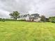 Spacious backyard with lush green lawn and view of white two-story home at 735 Davidson Run Ln, Davidson, NC 28036
