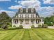 Stunning two-story home featuring a welcoming front porch, manicured lawn, and beautifully landscaped front yard at 735 Davidson Run Ln, Davidson, NC 28036
