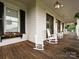 Charming front porch with rocking chairs, wood flooring and detailed trim at 735 Davidson Run Ln, Davidson, NC 28036