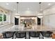 A marble kitchen island with flowers sits below decorative pendant lighting and a marble backsplash at 735 Davidson Run Ln, Davidson, NC 28036