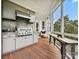 Covered porch featuring a grill, wooden floors, and outdoor seating near the large window at 735 Davidson Run Ln, Davidson, NC 28036