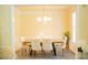 Bright dining room featuring a modern chandelier and seating for six at 7708 Harrington Woods Rd, Charlotte, NC 28269
