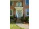 Close up of the front door with brick steps, wrought iron railing, sidelights and half-round transom at 7708 Harrington Woods Rd, Charlotte, NC 28269