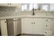 Modern kitchen with stainless steel dishwasher, white cabinets, and sleek subway tile backsplash at 7708 Harrington Woods Rd, Charlotte, NC 28269