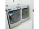 Modern laundry area features gray front-load washer and dryer at 7708 Harrington Woods Rd, Charlotte, NC 28269