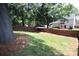 The expansive backyard features a sturdy wooden fence, green grass, and a lush tree line for privacy at 7830 Shiny Meadow Ln, Charlotte, NC 28215