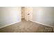 This comfy bedroom has neutral walls, plush carpet, and a door leading to the hallway at 7830 Shiny Meadow Ln, Charlotte, NC 28215