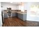 Modern kitchen featuring stainless steel appliances, granite countertops, and gray cabinets at 7830 Shiny Meadow Ln, Charlotte, NC 28215