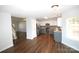 Open-concept kitchen with white upper cabinets, gray lower cabinets, and hardwood floors at 7830 Shiny Meadow Ln, Charlotte, NC 28215