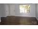 Bright living room with hardwood floors, neutral walls, window and door leading outside at 7830 Shiny Meadow Ln, Charlotte, NC 28215