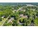 Expansive aerial view of a residential neighborhood with lush green trees and community pool, offering a serene living environment at 7921 Willhill Rd, Mint Hill, NC 28227