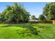 Expansive, well-manicured back yard with green grass and mature trees beyond the wooden fence at 7921 Willhill Rd, Mint Hill, NC 28227
