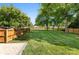 Spacious fenced back yard featuring lush grass, mature trees, and a brick patio at 7921 Willhill Rd, Mint Hill, NC 28227
