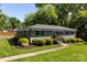 A gray brick single-story home featuring well-maintained landscaping and a charming walkway to the entrance at 7921 Willhill Rd, Mint Hill, NC 28227
