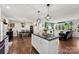 Bright kitchen with white cabinetry, a center island, and hardwood floors that opens to a dining and living space at 7921 Willhill Rd, Mint Hill, NC 28227