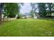 Large backyard with mature trees and partial fencing at 8742 Rittenhouse Cir, Charlotte, NC 28270