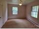 This bedroom features two window views and a ceiling fan at 9225 Robinson Church Rd, Charlotte, NC 28215