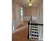Upstairs hallway with black and white staircase, wainscotting and doorways at 9225 Robinson Church Rd, Charlotte, NC 28215