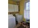 Practical laundry room with washer, dryer, ample storage, and a bright window at 9225 Robinson Church Rd, Charlotte, NC 28215