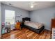 Cozy bedroom featuring hardwood floors, a ceiling fan, and a comfortable bed with a dark upholstered headboard at 9623 Duxford Ln, Charlotte, NC 28269