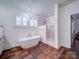 Bright bathroom showcasing a modern soaking tub, marble shower, chandelier, and wood-look flooring at 0000 Trull Hinson Rd # 2, Wingate, NC 28174