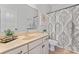 Well-lit bathroom features a cream vanity, neutral-toned walls and a patterned shower curtain at 10620 Euclid Nw Ave, Concord, NC 28027