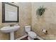 Half bathroom featuring a pedestal sink, toilet, and textured wall at 10620 Euclid Nw Ave, Concord, NC 28027
