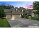 Beautiful brick home featuring a three-car garage, lush landscaping, and a well-manicured lawn at 10620 Euclid Nw Ave, Concord, NC 28027
