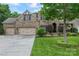 Beautiful two story brick home with an attached three car garage, an arched entryway, and mature trees at 10620 Euclid Nw Ave, Concord, NC 28027