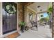 Inviting front porch with stone accents, seating, and a decorative wreath on the front door at 10620 Euclid Nw Ave, Concord, NC 28027
