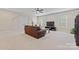 Spacious living room includes plush carpet, a ceiling fan, a leather couch, and natural lighting at 10620 Euclid Nw Ave, Concord, NC 28027