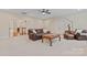 Bright living room features neutral carpet, a leather sofa, a ceiling fan, and ample natural light at 10620 Euclid Nw Ave, Concord, NC 28027