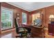 Spacious home office featuring a large desk, natural light, and hardwood floors at 10620 Euclid Nw Ave, Concord, NC 28027