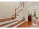 Elegant staircase with wood treads and white risers, leading to the upper level at 10620 Euclid Nw Ave, Concord, NC 28027