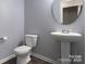 Modern half-bathroom with sleek pedestal sink and stylish fixtures at 11109 Pond Valley Ct, Charlotte, NC 28269