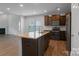 Modern kitchen featuring granite countertops, stainless steel appliances, and dark wood cabinets at 11109 Pond Valley Ct, Charlotte, NC 28269